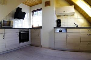 a large kitchen with wooden cabinets and a window at Schlossberghof Schnellingen in Haslach im Kinzigtal +4 photos