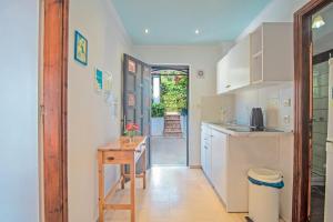 a kitchen with white cabinets and a wooden table at Andromaches apartment sea view 2 in Corfu