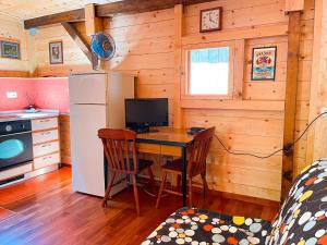 a kitchen with a desk with a refrigerator and a table at Le sorgenti - Chalet 12 in Palazzuolo sul Senio