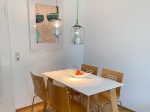 a dining room with a white table and chairs at Bodenseeloft H E 66 in Kressbronn am Bodensee