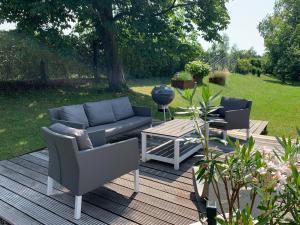 a patio with a couch and two chairs and a table at Bodenseeloft H E 66 in Kressbronn am Bodensee
