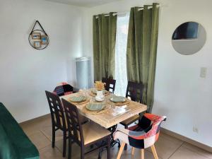 a dining room table with chairs and a wooden table and a table at Petit Loft, Maison Bord De Mer in Pirou