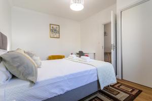 a white bedroom with a bed with white sheets at Oásis Fonte Grande in Santo António
