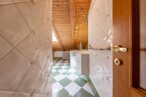 a bathroom with a shower and a checkered floor at Ciasa Sommavilla Mansarda in Vigo di Fassa +13 photos