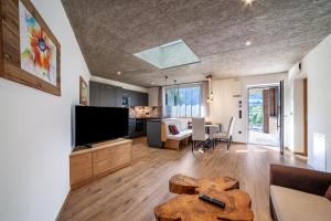 a living room with a television and a table at Chalet Riad 2 in Saltusio