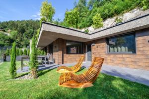 two chairs sitting in the grass in front of a house at Chalet Riad 2 in Saltusio
