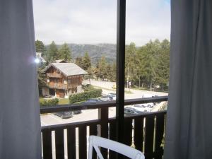 a room with a balcony with a view of a house at Studio Les Fontettes 2 in Le Dévoluy +4 photos