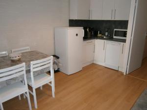 a kitchen with a table and a white refrigerator at Studio Les Fontettes 2 in Le Dévoluy