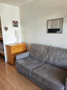 a leather couch in a living room with a mirror at Studio Les Fontettes 2 in Le Dévoluy