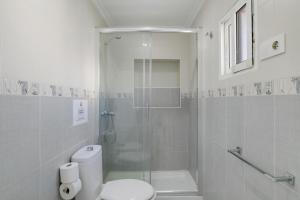 a white bathroom with a shower and a toilet at Piso Acogedor Tarifa Centro in Tarifa