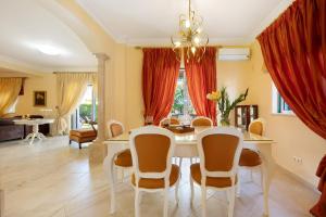 a dining room with a white table and chairs at Villa Tucha in Alvor