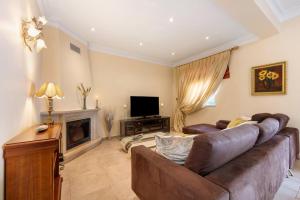 a living room with a couch and a television at Villa Tucha in Alvor