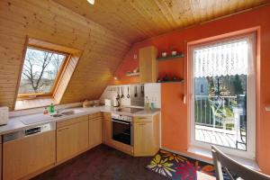 a kitchen with orange walls and a large window at Süd-Balkon an der schönen Peene in Demmin