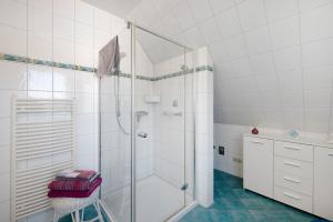 a white bathroom with a shower and a stool at Süd-Balkon an der schönen Peene in Demmin +20 photos