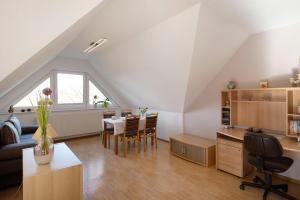 an attic room with a table and a dining room at Süd-Balkon an der schönen Peene in Demmin