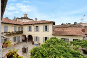 a large white house with red tile roofs at Quadrifoglio House in Ameno