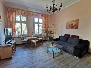 a living room with a couch and a table at Villa Adler- Seeseite in Ahlbeck