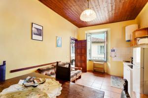 a living room with a table and a kitchen at Quadrifoglio House in Ameno