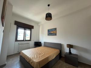 a bedroom with a bed and a lamp and a window at La casetta di Claudia in Nettuno