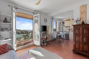 a living room with a couch and a kitchen with a balcony at Chez Skadi in Roquebrune-sur-Argens