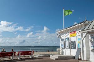 two people sitting on a bench in front of the beach at Appartement Le Moulleau in Arcachon +6 photos