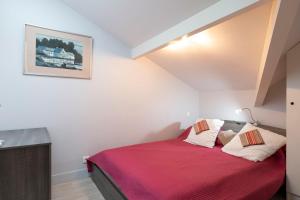 a bedroom with a bed with a red blanket at Appartement Le Moulleau in Arcachon