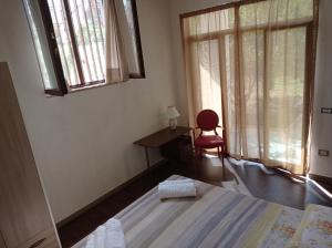 a bedroom with a bed and a desk and a window at Germogli di Prumo in Castelnuovo Cilento