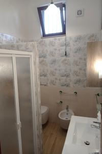 a bathroom with a sink and a toilet and a window at Germogli di Prumo in Castelnuovo Cilento