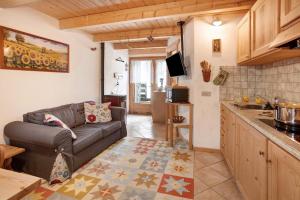 a living room with a couch and a kitchen at Taulain Gotrosio in Valdisotto +12 photos