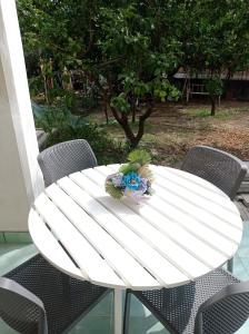 a white table with chairs and a bouquet of flowers on it at Germogli di Prumo in Castelnuovo Cilento +2 photos