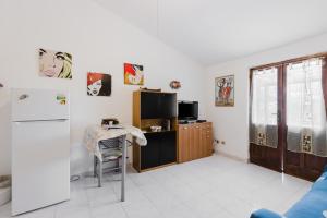 a kitchen with a refrigerator and a table in a room at Home Holidays Pintadera 2 in Bosa