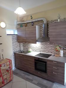 a kitchen with wooden cabinets and a stove top oven at Germogli di Prumo in Castelnuovo Cilento