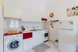 a kitchen with a washing machine and a sink at Home Holidays Pintadera 2 in Bosa +13 photos