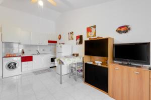 a kitchen with a tv and a table in it at Home Holidays Pintadera 2 in Bosa