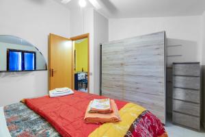 a bedroom with a bed with a large wooden headboard at Home Holidays Pintadera 2 in Bosa