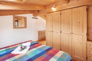 a bedroom with a bed and wooden cabinets at Taulain Gotrosio in Valdisotto