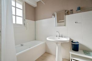 a white bathroom with a sink and a bath tub at Maison De Caractère in Cancale +19 photos