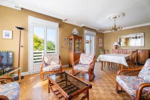 a living room with chairs and a table and a tv at Maison De Caractère in Cancale
