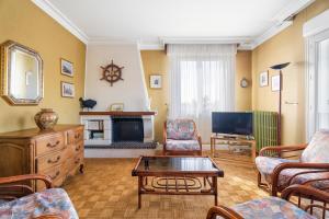 a living room with a couch and a tv at Maison De Caractère in Cancale