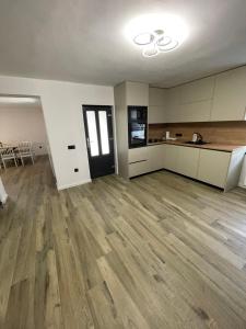an empty room with a kitchen and a hard wood floor at Cabana Patric Valea Avrigului in Avrig