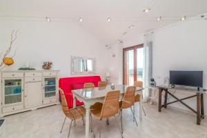a living room with a table and a red couch at B 104 Puntavilla Mare in La Maddalena