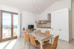 a kitchen with a table and chairs and a kitchen with a view at B 104 Puntavilla Mare in La Maddalena