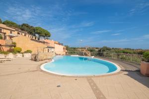a large swimming pool in a courtyard with buildings at B 104 Puntavilla Mare in La Maddalena