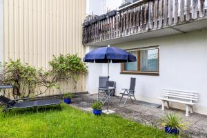 a patio with an umbrella and chairs and a bench at Ferienwohnung-4you in Sigmarszell