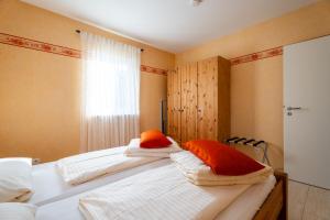 a bedroom with two beds with orange and white pillows at a Casa Mia by Kamelu in Gengenbach