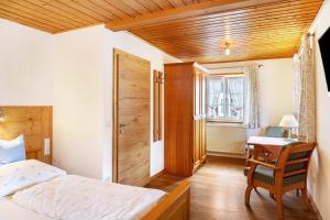 a bedroom with a bed and a desk and a chair at Ferienwohnung - Hexi in Bad Kohlgrub