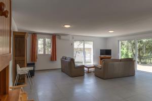a living room with two couches and a tv at Villa La Barbière in Sallelles