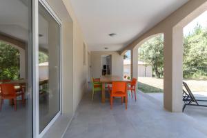 a dining room with orange chairs and a table at Villa La Barbière in Sallelles