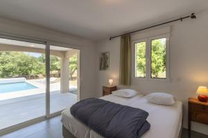 a bedroom with a bed and a swimming pool at Villa La Barbière in Sallelles +20 photos