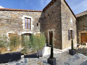 a stone building with a courtyard with cactus at Cocoon,Vue Montagne,Jacuzzi privé in Mostuéjouls